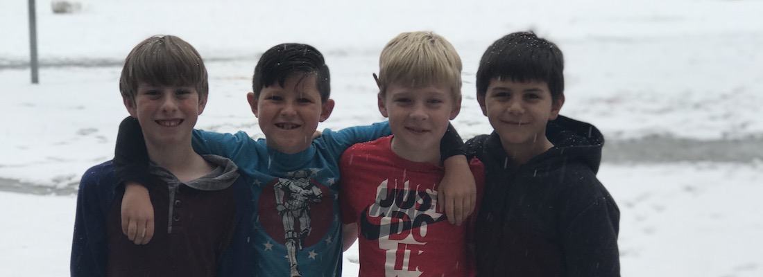 Four students posing outside in the snow